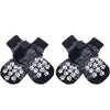Pair of black dog socks with white paw print traction straps