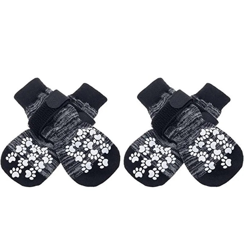Pair of black dog socks with white paw print traction straps