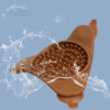 A brown silicone licking mat for pets is shown being used, with water splashing around it.