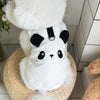 A white waffle knit pet vest for dogs or cats is shown resting in a woven basket.