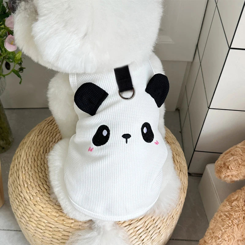 A white waffle knit pet vest for dogs or cats is shown resting in a woven basket.