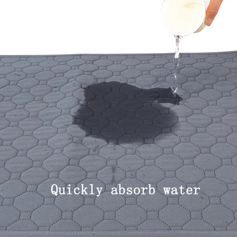 A clear liquid is dripping onto a dark gray, hexagonal pet training mat, creating a shadow.