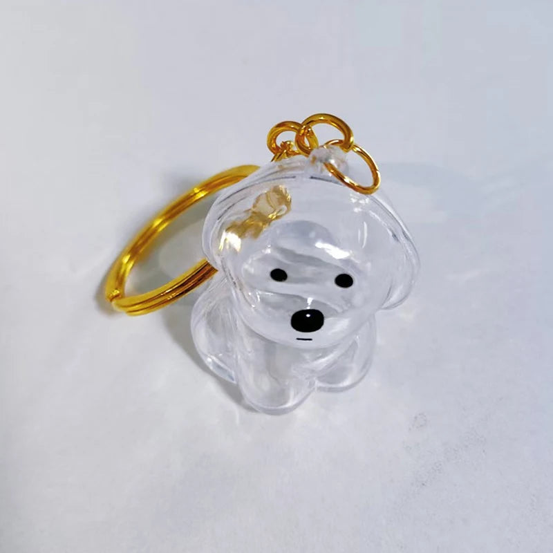 Klares Glas-Anhänger in Form eines Hundekopfes, befestigt an einem goldfarbenen Schlüsselring.