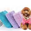 A pile of fluffy, multi-colored chenille pet bath towels in shades of blue, purple, and pink, displayed on a white surface.