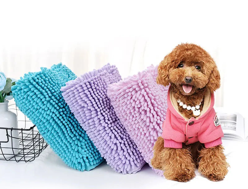 A pile of fluffy, multi-colored chenille pet bath towels in shades of blue, purple, and pink, displayed on a white surface.