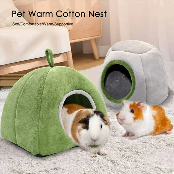 A green plush cave bed for a small rodent is shown with a small orange and white rabbit resting inside.