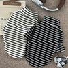 Black and white striped thermal dog sweater laid flat on a beige surface.
