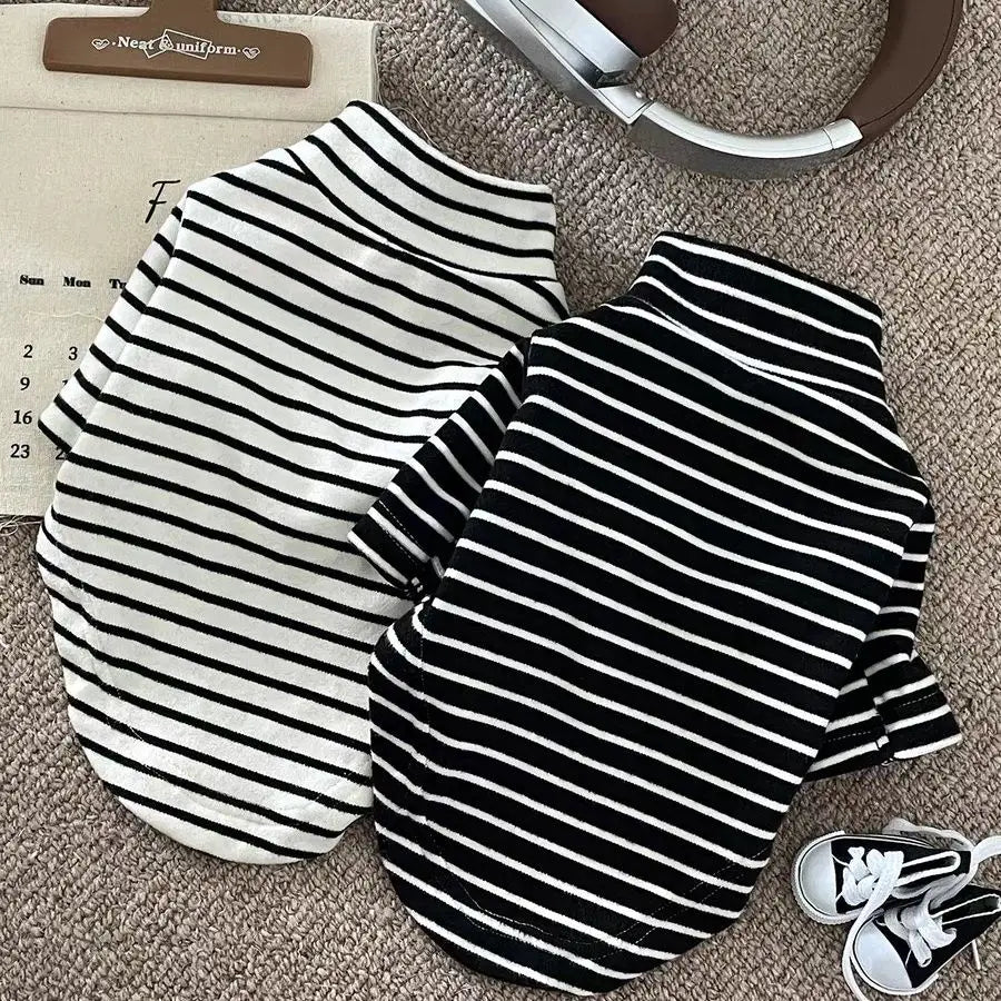 Black and white striped thermal dog sweater laid flat on a beige surface.
