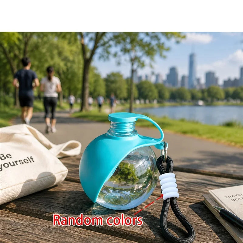 A bright blue portable pet water bottle with a black lanyard resting on a wooden surface.
