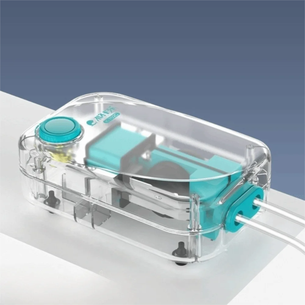 Clear plastic aquarium air pump with a light blue component and tubing resting on a white surface.