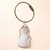 A clear glass cat figurine keychain with black whiskers and eyes hanging from a braided cord.