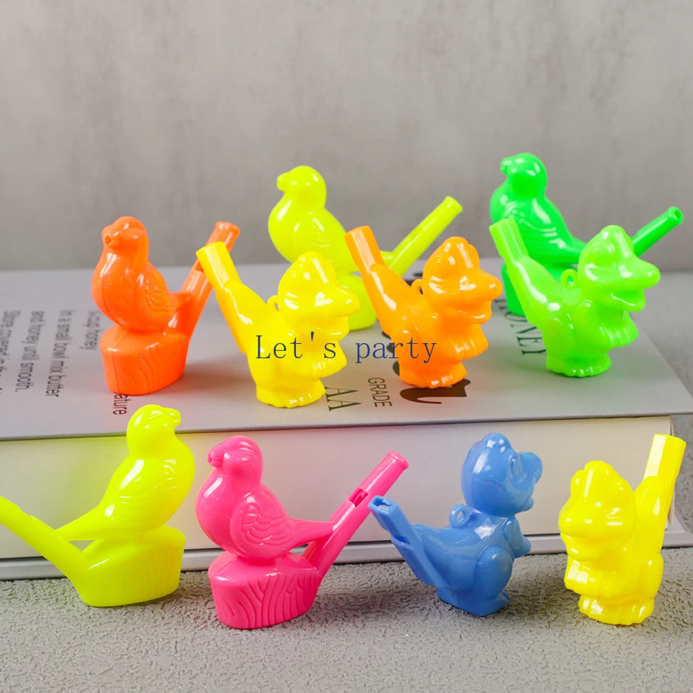 A collection of ten colorful bird and dinosaur water whistles in various bright colors arranged on a white book.