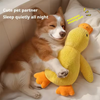 A dog is resting next to a yellow plush duck toy on a white bed.
