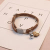 Brauner Lederhalsband für Haustiere mit silberner Sicherheitsglocke und Tan-Pfotenabdruck-Anhänger auf weißem Hintergrund.