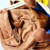 A close-up of a brown faux fur cowboy jacket for dogs with blue and white trim.