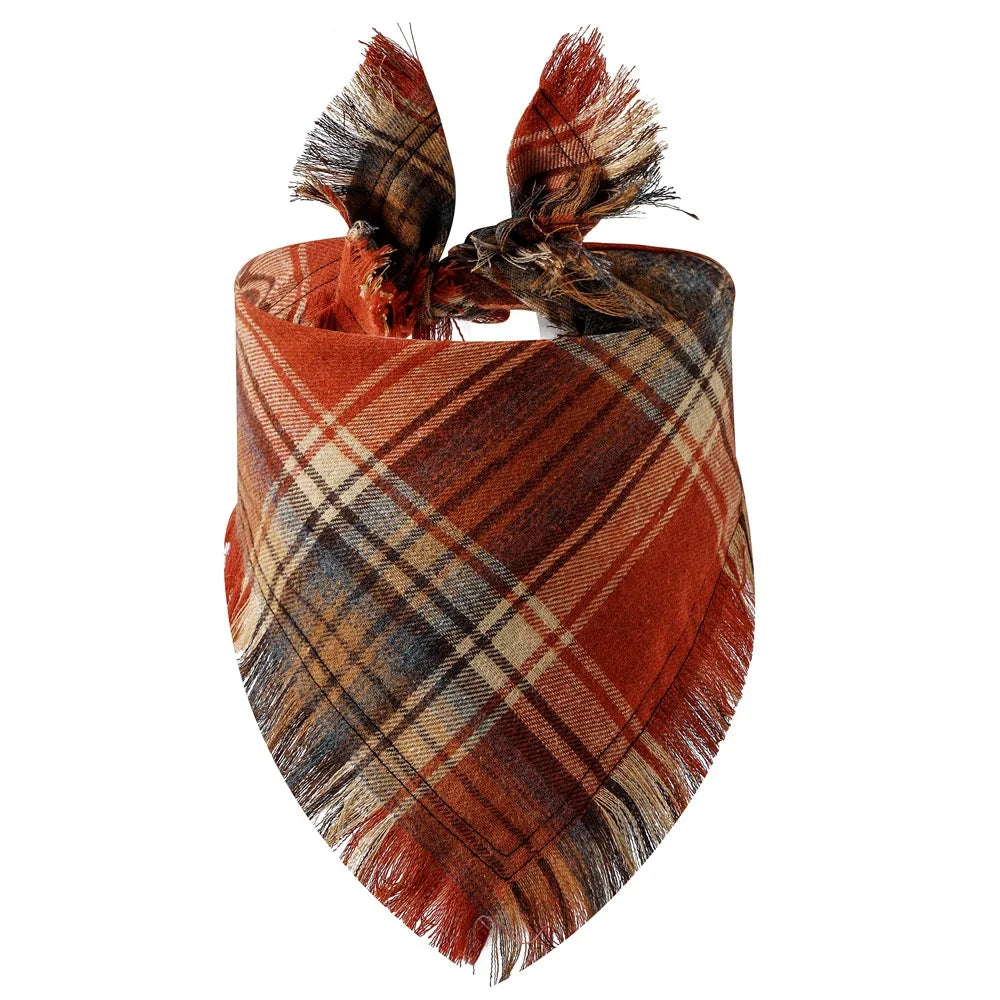 A plaid dog bandana in shades of rust, brown, and tan with fringed ties.