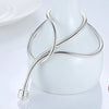 A silver snake chain necklace with a heart charm displayed on a white mannequin.