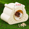 A beige cartoon hamster hideout house with a viewing window is placed on green grass.