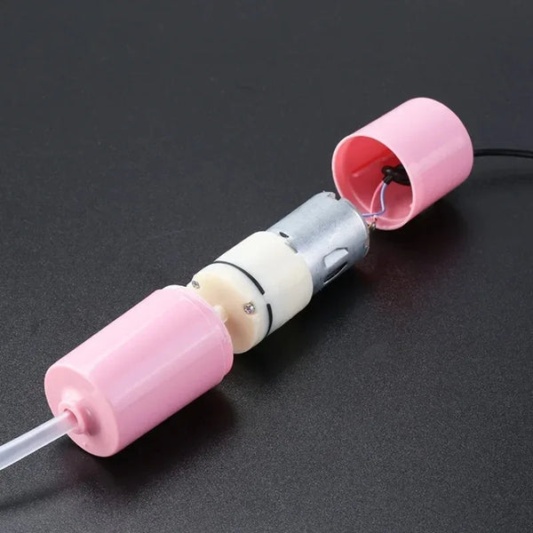 A pink and silver portable USB aquarium air pump with a clear tube and a pink nozzle.