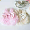 Vestidos florales rosas y crema para mascotas, junto a una taza y un cuaderno.