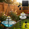 A solar-powered hanging bird bath fountain with a glass bowl and water spouts, suspended by a chain.