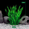 Un touffe de plantes aquatiques artificielles vert vif poussant dans un petit jardin de roches.