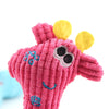A pink, textured plush toy shaped like a giraffe with yellow accents and a smiling face.