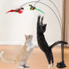 Eine schwarze Katze interagiert mit einem langen Spielstäbchen mit toter-ähnlichen Figuren.