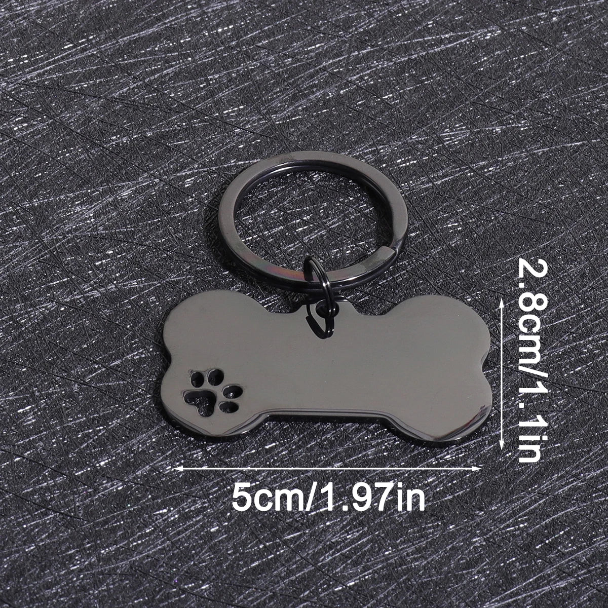 A silver bone-shaped dog ID tag with a keyring, measuring 5cm long and 2.8cm high.