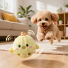 A fluffy yellow squeaky bouncing chick ball for pets is shown jumping on a wooden floor.