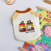 A cream-colored pet vest shirt with a yellow collar and a graphic of a Bao family cooking.