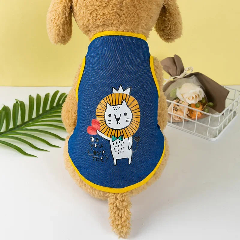 A brown dog wearing a blue mesh vest with a yellow trim featuring a white cat and a lion face print.