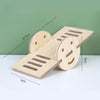 A natural wooden hamster house and activity platform with various openings and a smiling face design.