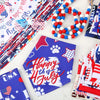 A collection of patriotic dog and cat bandanas featuring red, white, and blue patterns laid out on a white surface.