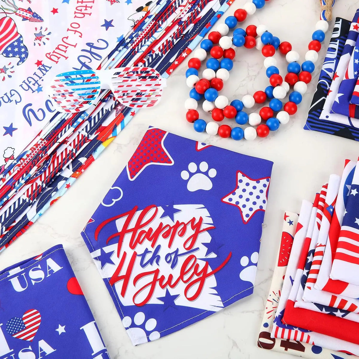 A collection of patriotic dog and cat bandanas featuring red, white, and blue patterns laid out on a white surface.