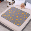 A gray patterned waterproof cartoon bed protector pad is placed on a light-colored bed.