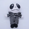 A plush toy of a cartoon skeleton dog with black features and striped clothing.