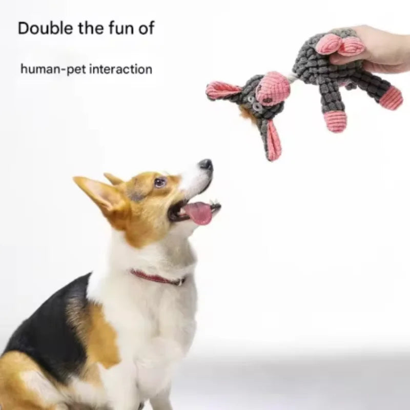 A fluffy dog is interacting with a handmade plush squeaky donkey toy.