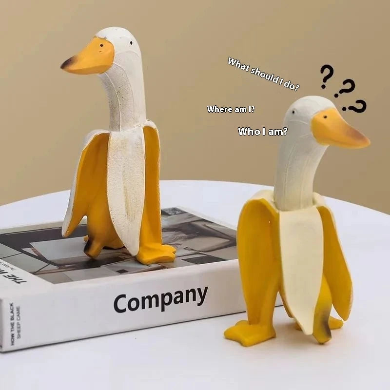 A yellow and white resin banana duck garden sculpture is displayed on a box with text asking what someone should do or who so