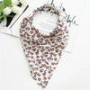 A patterned bohemian paisley triangle scarf in beige and purple floral print displayed on white paper.