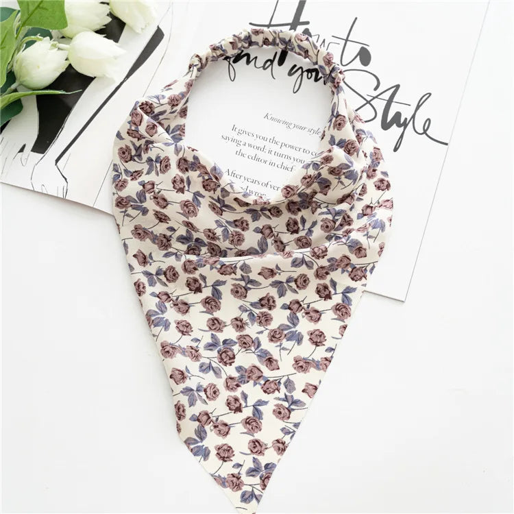 A patterned bohemian paisley triangle scarf in beige and purple floral print displayed on white paper.