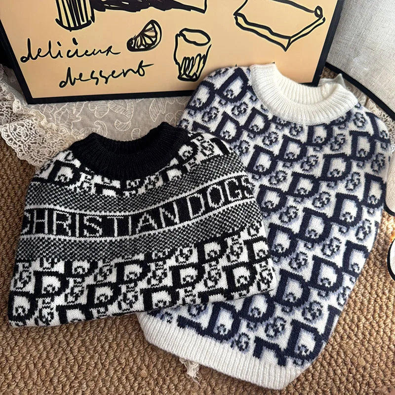 A black and white patterned knit sweater for dogs displayed next to a box.