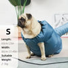 A light brown dog is sitting next to a blue pet drying bag with measurements displayed.