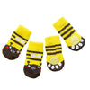 A pack of four yellow and black striped anti-slip pet socks for dog and cat protection.