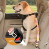 A golden retriever sits in a car seat with an adjustable safety buckle and elastic bungee buffer attached to its collar.