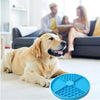 Ein goldener Retriever liegt auf einem hellen Boden neben einer blauen Silikon-Lickmatte für Haustiere.