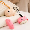A pink reusable pet hair roller with a cute cartoon design is shown resting on a white towel.