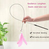 A hand is holding an elastic steel wire rod with a pink feather toy attached, demonstrating its resilience and length.