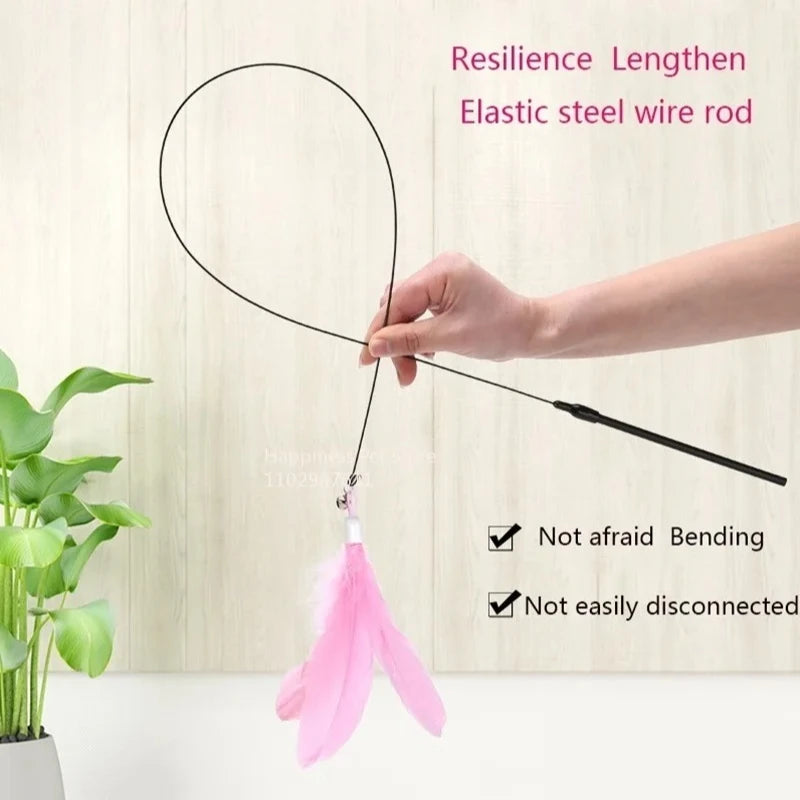 A hand is holding an elastic steel wire rod with a pink feather toy attached, demonstrating its resilience and length.