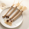 Several natural silvervine cat chews and dental health toys tied with twine are displayed on a white plate.